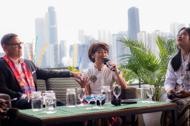 Sesi diskusi peluncuran kampanye Plesiran di Jakarta dengan pembicara menggunakan mikrofon di rooftop Jakarta