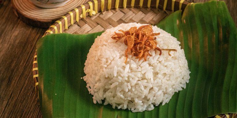 Sejarah nasi uduk Betawi sebagai kuliner khas Jakarta yang berasal dari tradisi ritual masyarakat Betawi dan berkembang menjadi makanan favorit hingga saat ini.