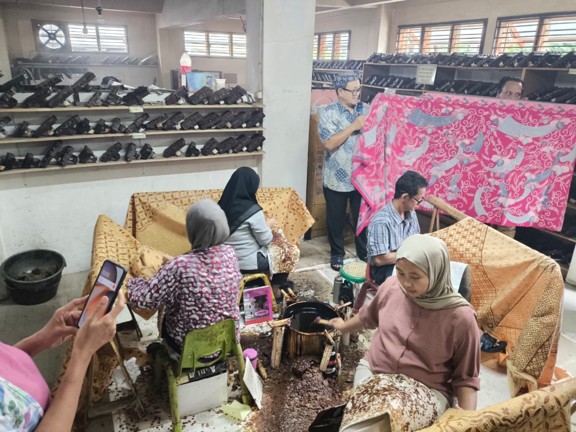 Perajin menunjukkan proses pembuatan batik tulis menggunakan canting dan malam panas di Rumah Batik Komar Bandung.